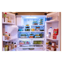 Glass food storage containers with teal lids inside a refrigerator