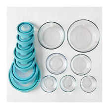 Assorted glass food storage containers with teal lids and clear glass bases, top-down view