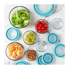 Glass food storage containers with teal lids arranged around prepared ingredients