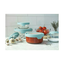 Round glass food storage containers with teal lids on a countertop