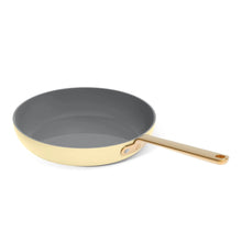 Buttercream nonstick fry pan with dark interior and long gold handle