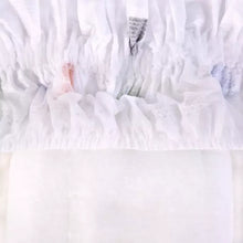 Packaged white diapers with gathered outer layer, soft fabric texture visible