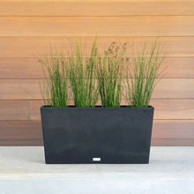 Veradek dark trough planter with tall green grass, rectangular modern design