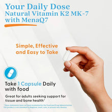 Hand holding a white veggie capsule for Vitamin K2 MK-7