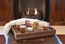 Clear glass mug set with assorted drinks on a wooden serving tray