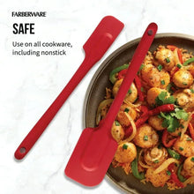 Red silicone spatula set with solid heads scraping food in a skillet