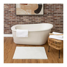 White plush bath rug with short pile, laid flat on the floor