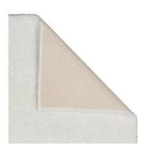 Plush bath rug corner with textured underside edge and short pile