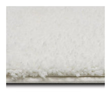 Plush bath rug edge with dense low pile and fabric backing
