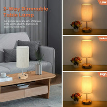 Touch table lamp with cream fabric shade and wood base on a living room side table