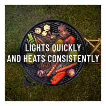 Charcoal briquettes heating on a grill grate with skewers and lit coals