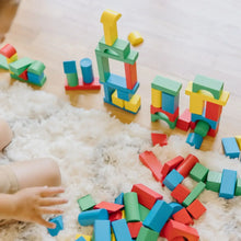 Colorful wooden blocks arranged for building, including arches, pillars, and rectangles.