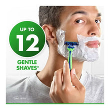 Disposable 3-blade razor with teal-and-green handle in shaving foam on face.
