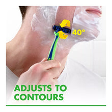 Disposable razor with blue-and-green handle shaving foam on face, 3-blade head.