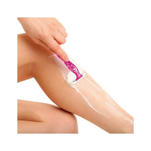 Disposable 3-blade razor shaving a leg with white foam.