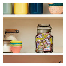 Glass candy jar filled with assorted M&M's, Snickers, Milky Way, and Twix minis.
