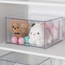 Clear plastic closet drawer with pull handle, holding plush toys and balls