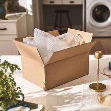 Small bubble cushioning wrap inside cardboard shipping box, white