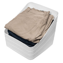 White plastic slanted storage bin holding folded jeans and shirts