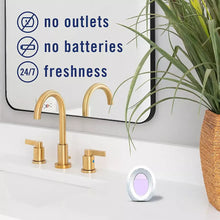 Febreze bathroom air freshener plug-in near two gold faucets, oval scent window