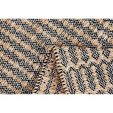 Textured woven rug surface with black, white, and beige stripe-like pattern