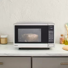 Stainless steel microwave oven on kitchen counter with door and control panel