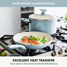 Light blue covered stockpot on a gas stove with herbs and sliced food