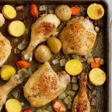 Seasoned chicken pieces with sliced vegetables in a baking tray