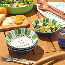 Sardine-themed cereal bowls stacked, green and blue striped rims, salads nearby