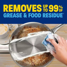 Dish soap foam on a skillet while cleaning with a blue-and-white sponge