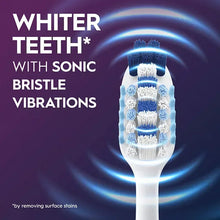 Toothbrush bristles on a white tooth with blue sonic vibration glow