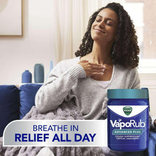 Vicks VapoRub Advanced Plus chest rub jar beside a person rubbing the throat