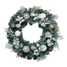 Green faux floral wreath with white blossoms, silver baubles, and LED lights
