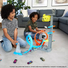 Hot Wheels track set with orange and blue loops and gray launch tower, cars