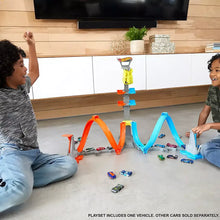 Hot Wheels track set with orange and blue loops and launch tower, loose cars