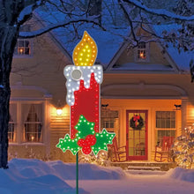 Lit LED candle decoration with holly leaves and berries, glowing flame