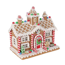 Gingerbread house decoration with glowing accents, door details, and garland roof