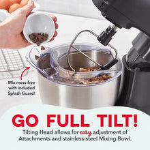 Black stand mixer with splash guard and stainless bowl, hand adding ingredients.