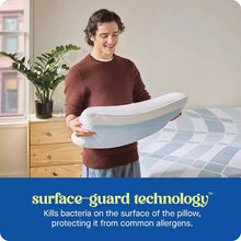 Cooling gel memory foam pillow with white cover and blue wave stripe, held above bed