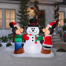 Inflatable snowman decoration with two Mickey-style characters in Santa hats and green shirts