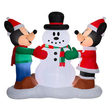 Inflatable snowman centerpiece with two characters in red-and-white Santa hats, green sleeves