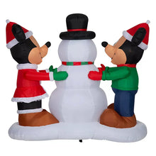 Inflatable snowman with top hat and two characters facing inward, Santa hats and festive outfits