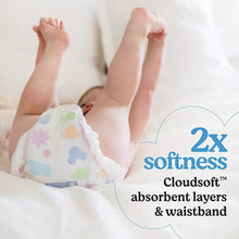 Baby lying down in a white diaper with colorful prints and Cloudsoft softness callout
