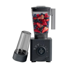 Countertop blender with clear jar filled with berries and dark base control dial
