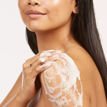 Body wash lather on skin with pump applicator held near the shoulder