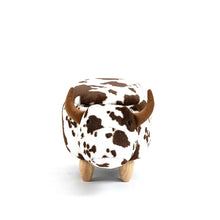 Cow-print ottoman stool, front view, with hornlike ears and wooden legs