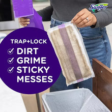 Swiffer WetJet cleaning pad held by hand, beige textured cloth with purple trim stripes