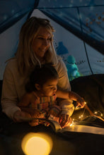 Blue kids bed tent interior with warm glowing lights and starry decals on the walls
