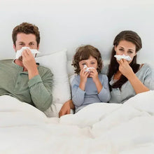 Family members using facial tissues while sitting on a couch
