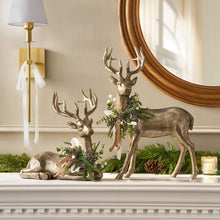 Set of 2 holiday deer ornaments: bronze antlered deer with pine and ribbon accents